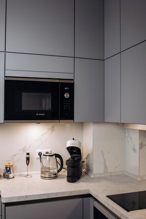A kitchen with a Bosch microwave, a coffee maker, and a glass carafe on the counter. - Vrbo Property (Reichenbach im Vogtland)
