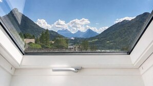 A skylight with a view of mountains and a clear sky.
