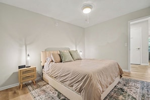 A bedroom with a bed, bedside table, lamp, and a patterned rug. - Game Day Luxury | 2B/2BA Condo By ND | Balcony (South Bend)