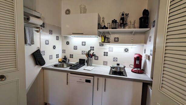 A kitchen with a dishwasher, a coffee maker, and various utensils on the counter. - Studio le banga (Ax-les-Thermes)
