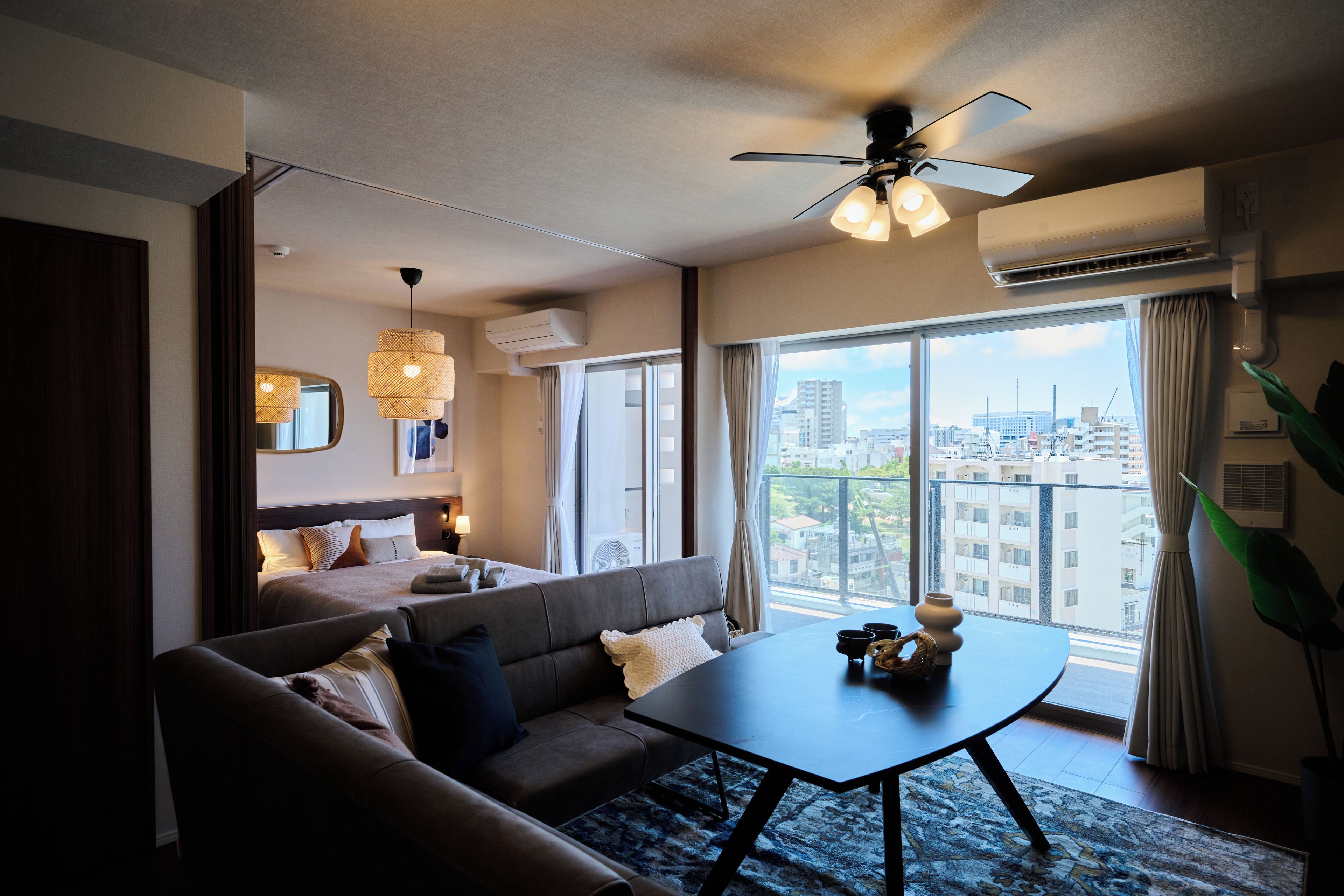 Habitación de hotel moderna con sofá, una mesita de café y vistas a la ciudad.