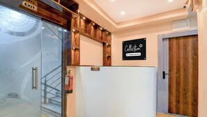 A reception desk with a 'RECEPTION' sign, a 'COLLECTION' sign, and a wooden door. - Collection O Park Street Road (Kolkata)