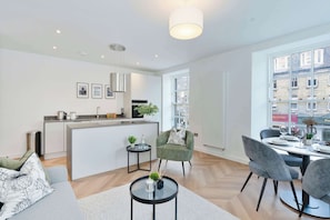 Eine moderne Wohnung mit Küche, Essbereich und Blick auf die Stadt.
