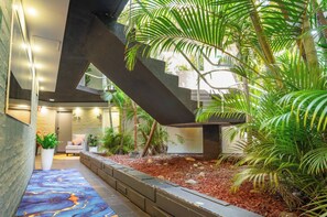A modern interior with a staircase, indoor plants, and a seating area.