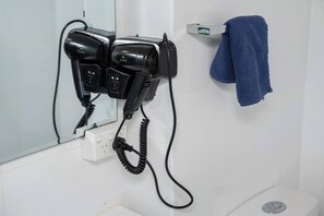 Un secador de pelo y un perchero en un baño.