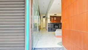 Zona de recepción de un hotel, con mostrador de recepción, un cartel que indica 'Reception' y un cartel que dice 'Collection'.