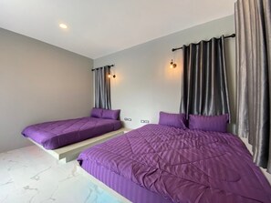 Une chambre avec deux lits, un mur de couleur claire et un luminaire au plafond.