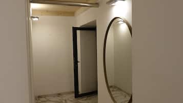 Un baño con piso de mármol, techo de madera y un espejo grande.