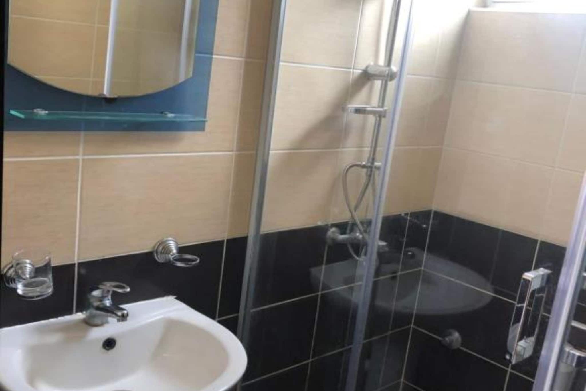Une salle de bain avec une douche à parois de verre, un lavabo et des toilettes.