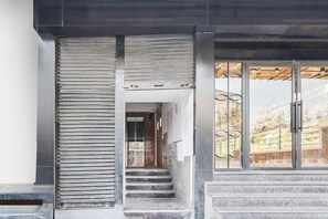 A modern building entrance with a metal staircase leading to a glass door. - Super Collection O Nirman Vihar (New Delhi)