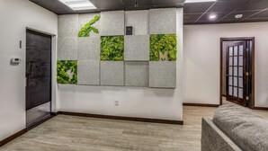 A hallway with a textured wall, a door, and a bench.