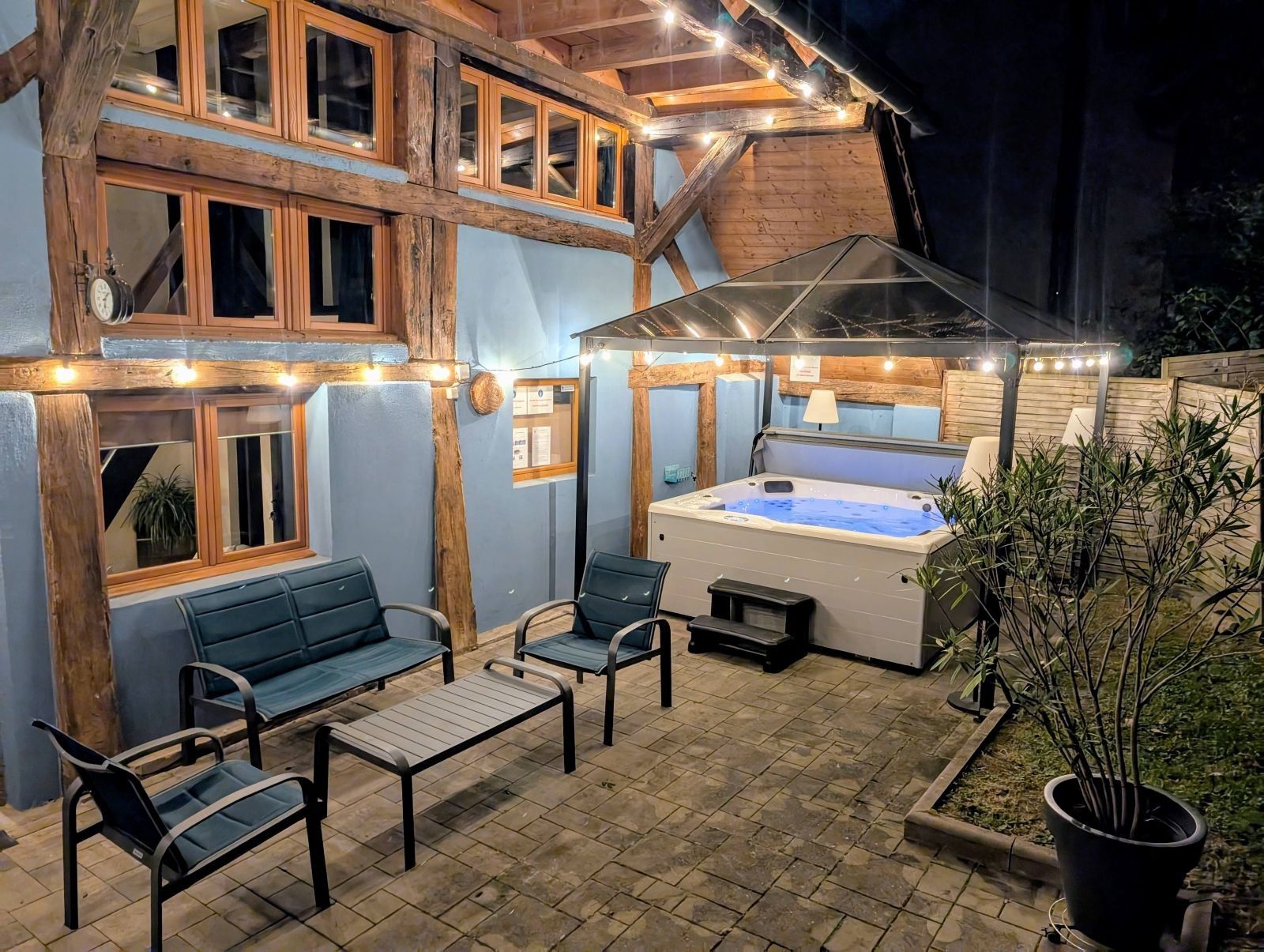 Ett utomhusområde med en uppvärmd pool och sittplatser, samt en täckt uteplats.