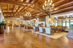Eine großzügige Lobby mit Holzböden, mehreren Sitzgelegenheiten und einem Kamin.