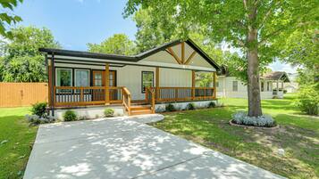 A single-story house with a front porch, a covered entryway, and a well-maintained lawn.
