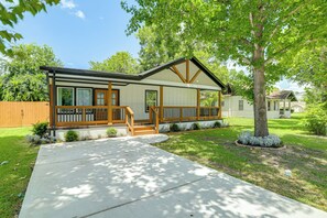 Ein eingeschossiges Haus mit Veranda, überdachter Eingangspforte und gepflegtem Rasen.