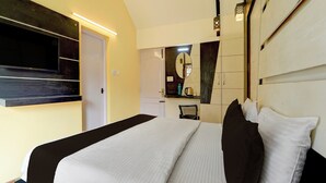 A hotel room with a bed, a flat-screen TV mounted on the wall, a mirror, and a coffee machine. - Super Collection O Hill View Point (Kodaikanal)