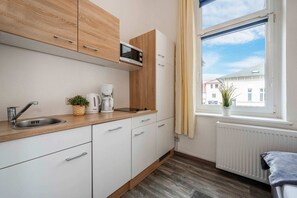 Eine moderne Küche mit Mikrowelle, Kaffeemaschine und Spüle.