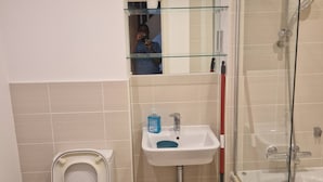 A bathroom with a toilet, sink, and shower. - A friendly budget room that delivers comfort stay (Woolston)