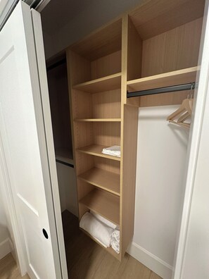 A walk-in closet with multiple shelves and a hanging rod. - Cozy Burnaby Heights Suite Private 1BR + 1 Bath (Burnaby)