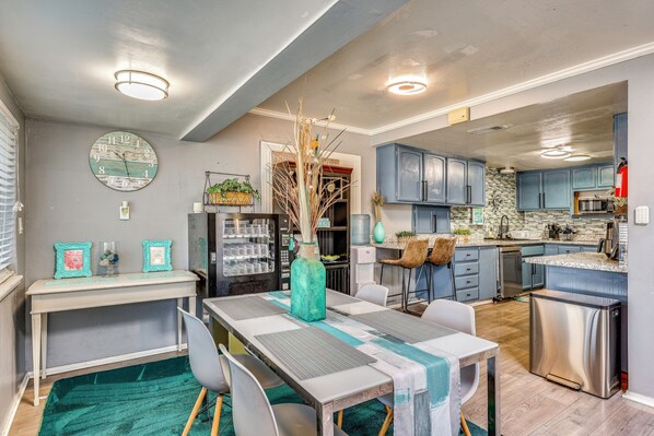 A modern kitchen with blue cabinets, a stainless steel refrigerator, and a microwave.