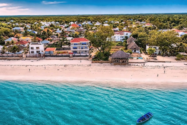 A coastal town with beachfront properties, a sandy beach, and clear turquoise waters.