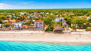 Resort costeiro com villas na praia, piscina e acesso direto à areia.