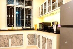 A kitchen with a stainless steel refrigerator, a coffee maker, and a microwave on the countertop. - Private 2-Bedroom Beachfront Apartment in Uroa, Zanzibar (Zanzibar, Uroa)