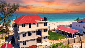 Um imóvel à beira-mar com vários edifícios, piscina e vista para o oceano.