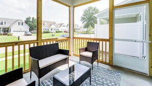 A covered porch with wicker furniture and a view of a residential neighborhood. - 3 Mi to Wilson! Sleek Townhome w/ Screened Porch (Wilson)