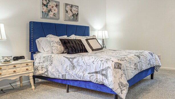 A bedroom with a bed, bedside tables, and wall art. - Private Yard & Patio! Overland Park Group Getaway (Overland Park)