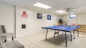 A room with a ping pong table, a sofa, and a television. - Private Yard & Patio! Overland Park Group Getaway (Overland Park)