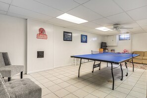 A room with a ping pong table, a sofa, and a television. - Private Yard & Patio! Overland Park Group Getaway (Overland Park)