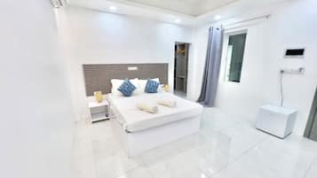 A modern hotel room with a large bed, bedside table, and a ceiling fan.