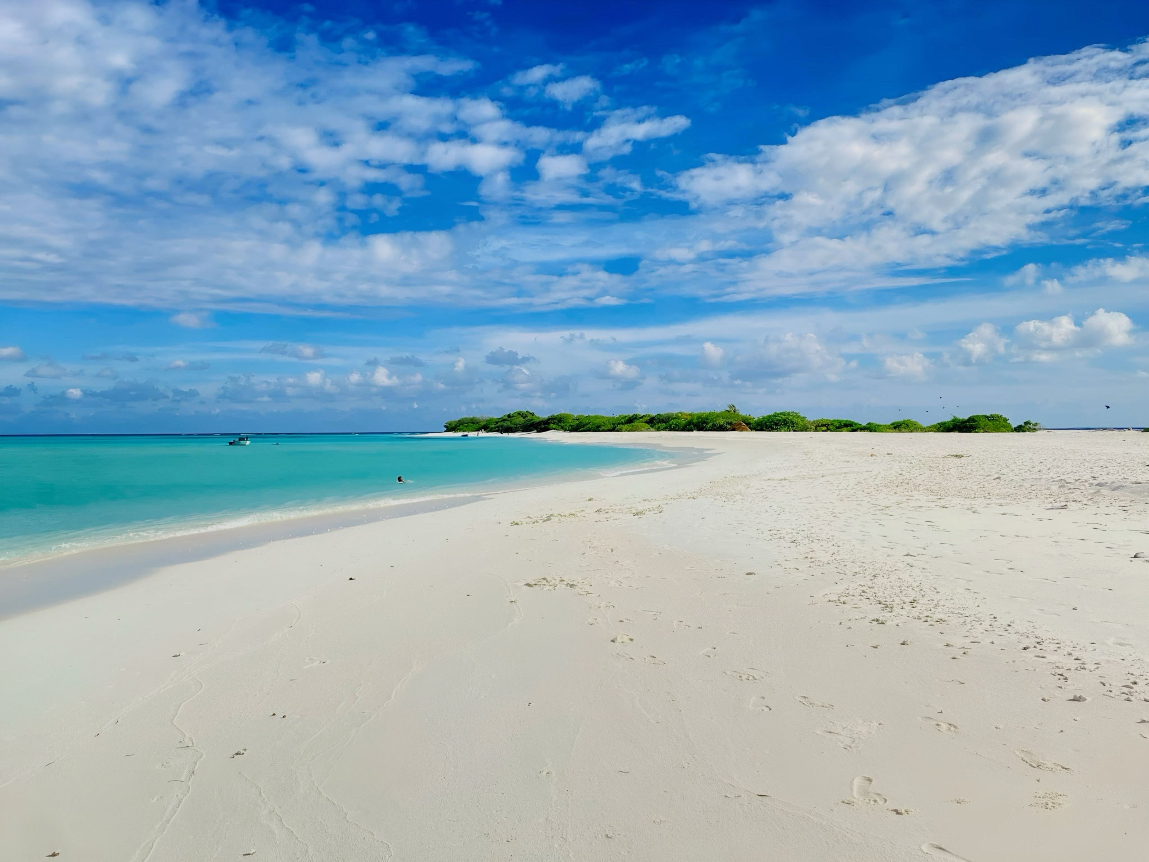 Una playa con arena blanca y agua turquesa cristalina.