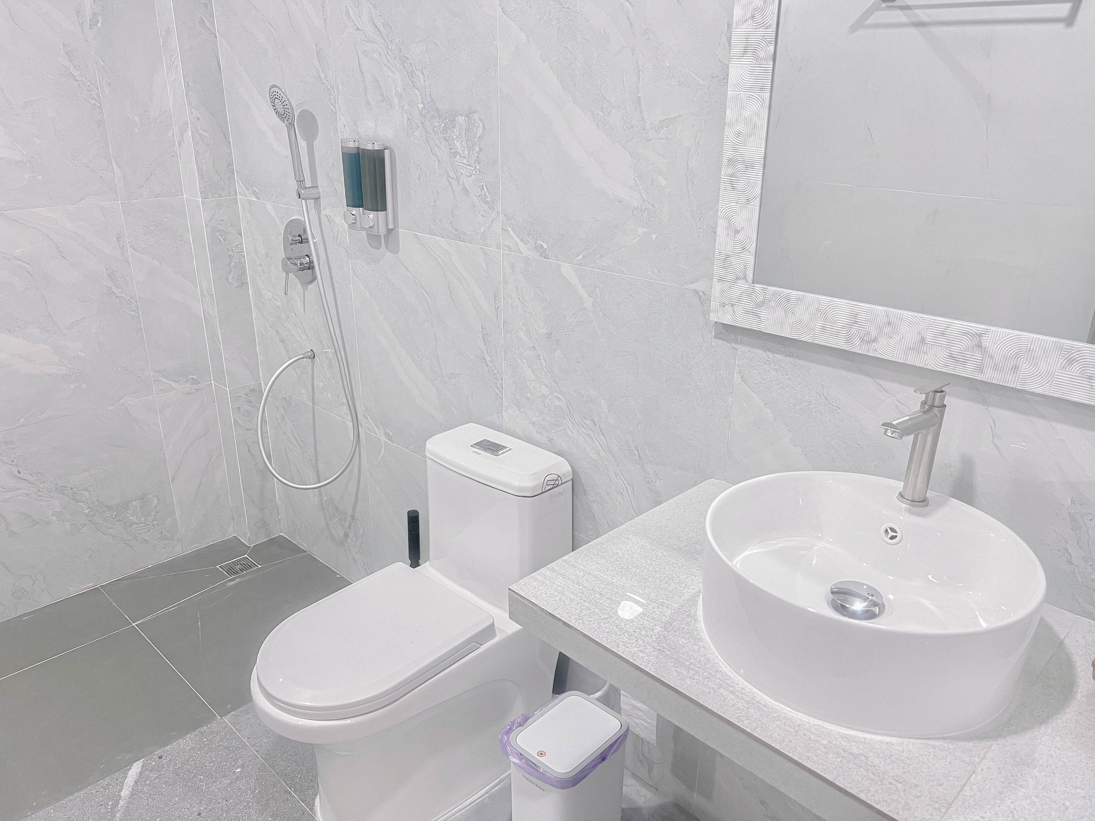 Une salle de bain moderne équipée de toilettes, d’un bidet, d’un lavabo et d’une douche.