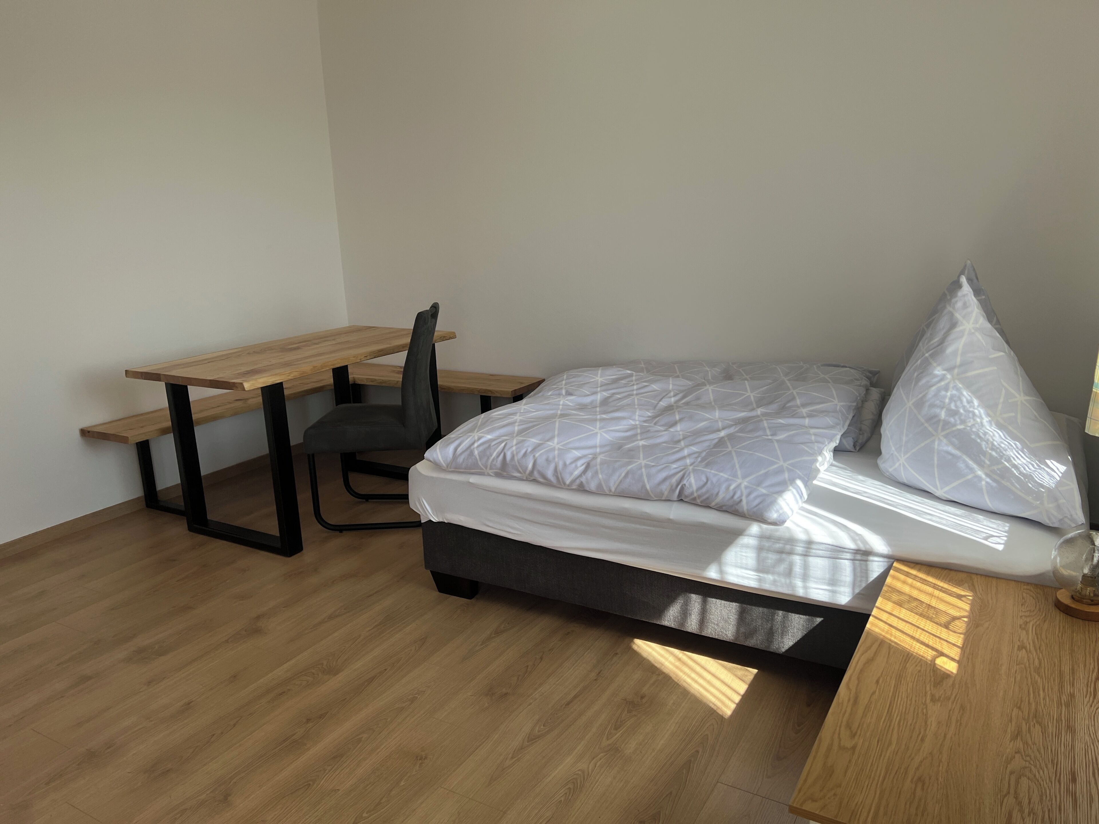 Un dormitorio con cama, escritorio y silla.