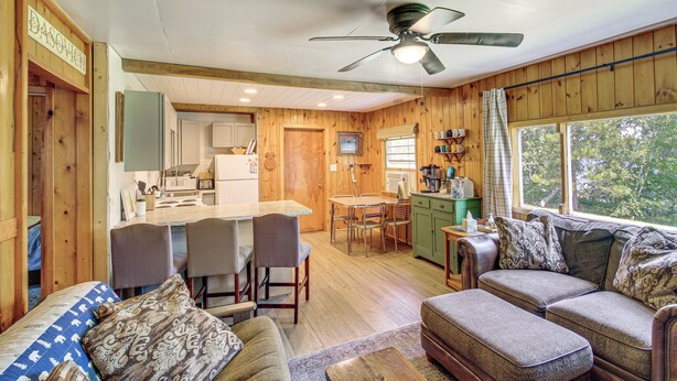 Un intérieur en bois comprenant un coin repas, une cuisine et un espace salon.