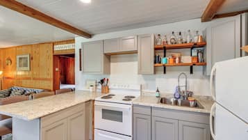 A kitchen with wooden cabinets, a white stove, and a countertop with various kitchen items.