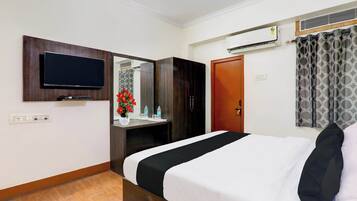 Une chambre d’hôtel équipée d’un lit, d’une télévision, d’un miroir, d’une armoire et d’un appareil de climatisation.