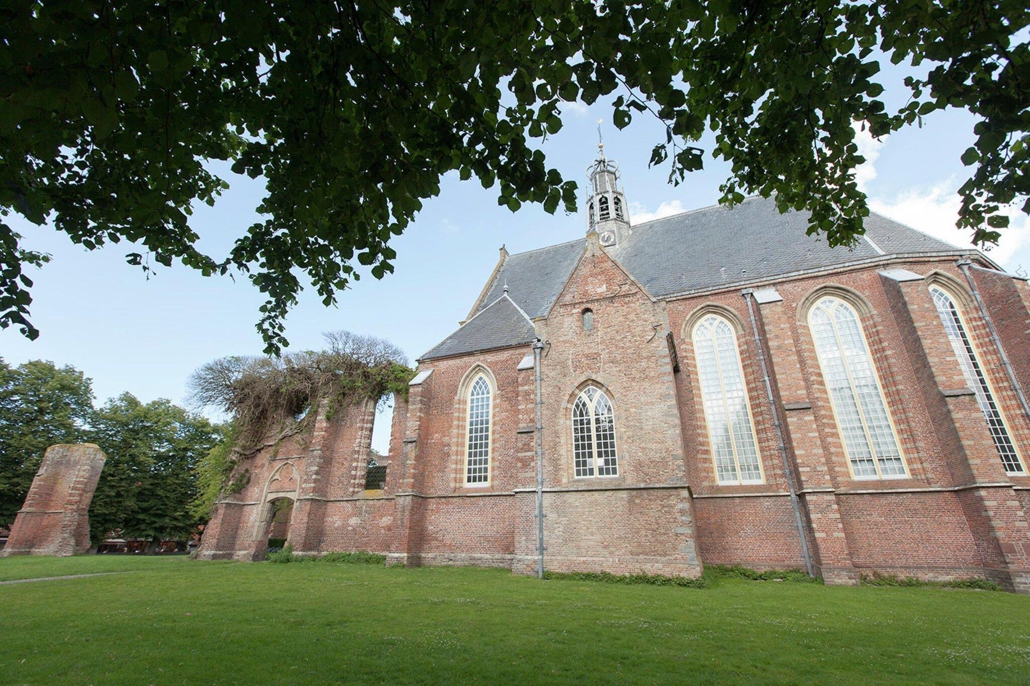 A historic church with a prominent steeple and large arched windows.