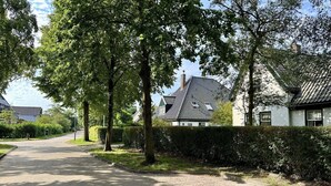 A paved pathway leading to a row of traditional houses with sloped roofs and a well-maintained hedge. - Lovely holiday home centrally located in Bergen in delightful surroundings. (Bergen)