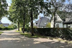 A paved pathway leading to a row of traditional houses with sloped roofs and a well-maintained hedge. - Lovely holiday home centrally located in Bergen in delightful surroundings. (Bergen)