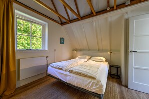 A bedroom with a bed, a window, a door, and a small table. - Lovely holiday home centrally located in Bergen in delightful surroundings. (Bergen)