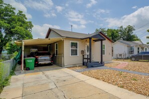 Ein Wohnhaus mit Garage, überdachter Veranda und Auffahrt.