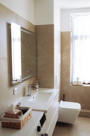 A modern bathroom with a large mirror, a sink, a toilet, and a window with curtains. - Vrbo Property (Reichenbach im Vogtland)