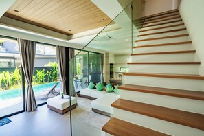 A modern interior with a staircase, a pool, and a dining area. - Villa Koa 4BR at Aileen Villas Layan (Choeng Thale)