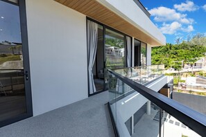 A modern building with large windows, a balcony with glass railings, and a view of the surrounding area. - Villa Koa 4BR at Aileen Villas Layan (Choeng Thale)