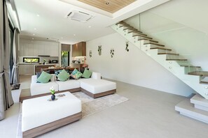 Una sala de estar moderna con un conjunto de sofá, una mesa de centro y una escalera.