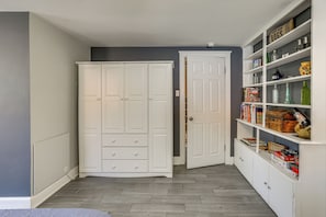 Una habitación con armario, una puerta y estante con diversos objetos.