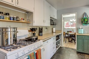 A kitchen with a stove, oven, and various kitchen utensils. There is a window with a view of a red building outside. - Spacious Denver Getaway w/ Pool, Hot Tub & More (Denver)